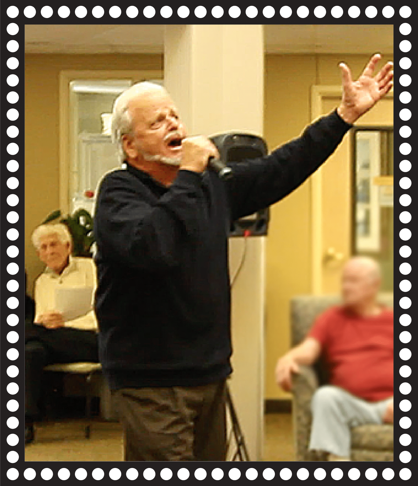 man singing with arms in air with microphone